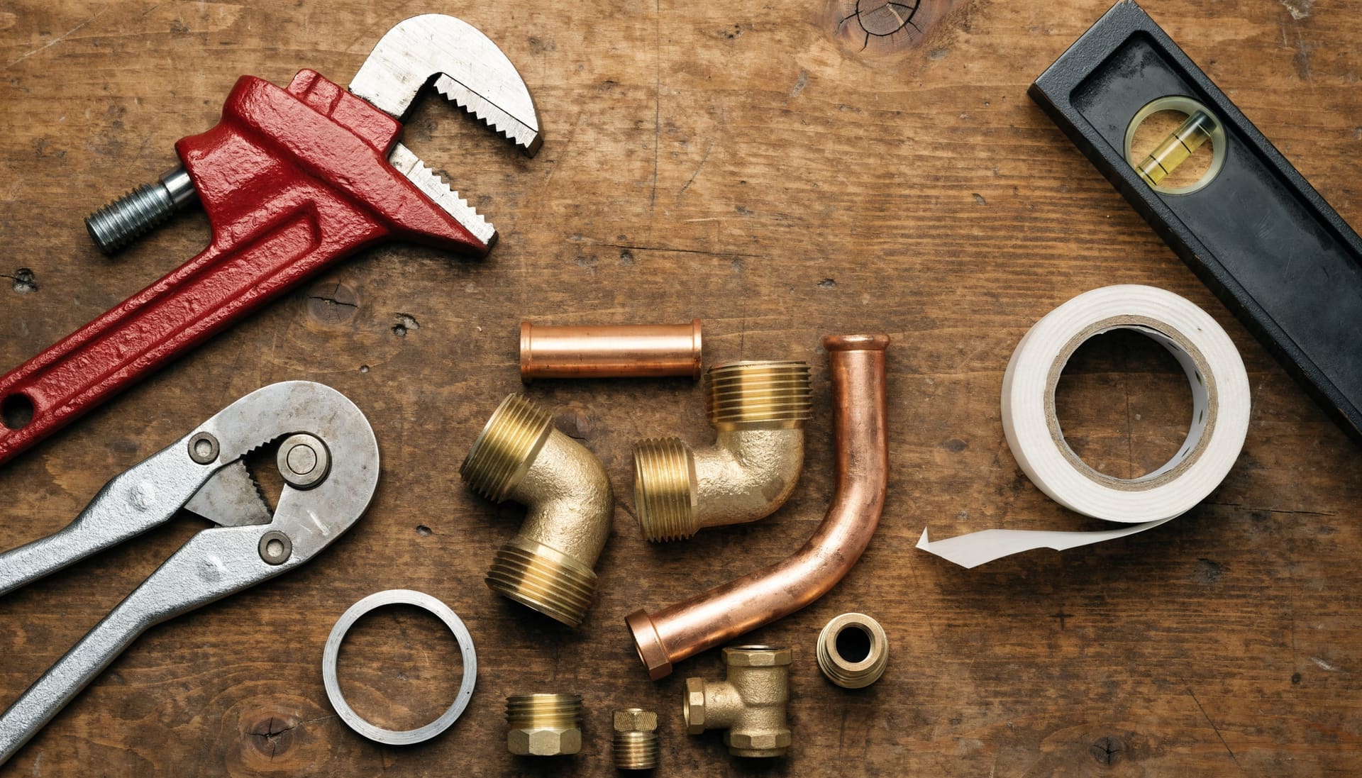 Plumbing hand tools laid out on a workbench (representative image)